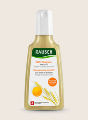 A bottle of Rausch Nähr-Shampoo (nutritive shampoo) with Eri-Oil, featuring a white cap and a label with green, orange, and yellow graphics on a light beige background.