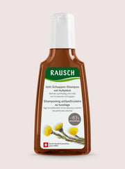 A bottle of Rausch Anti-Schuppen-Shampoo against a solid pale pink background. The bottle is brown with a white cap and a white label featuring green and yellow details.
