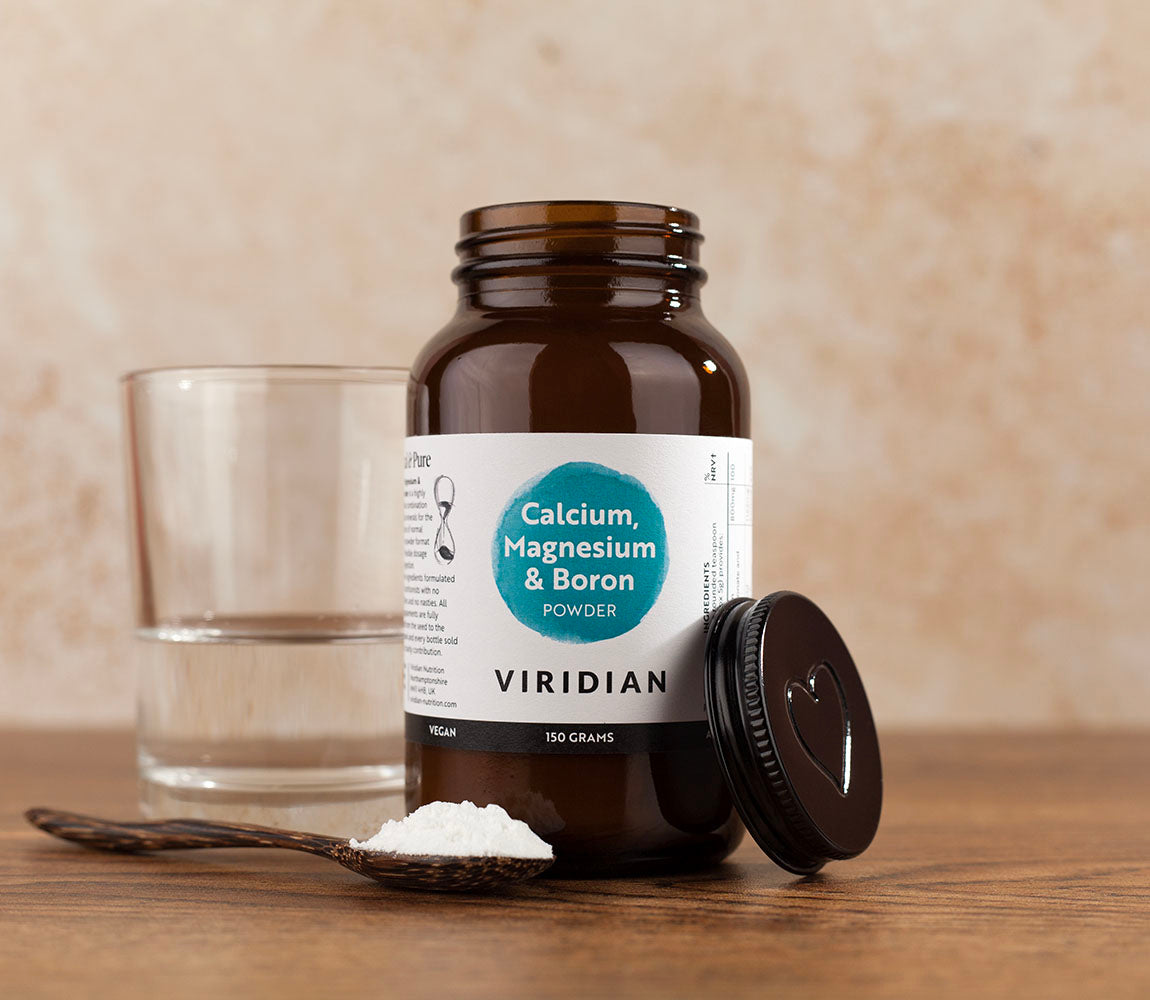 Viridian supplement bottle with a spoonful of powder on a wooden surface