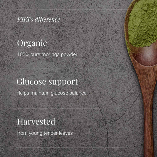 Promotional graphic for KIKI organic moringa powder, featuring white text highlighting key benefits ('Organic', 'Glucose support', 'Harvested from young tender leaves') on a textured dark gray background, alongside a wooden spoon filled with bright green moringa powder on the right side.