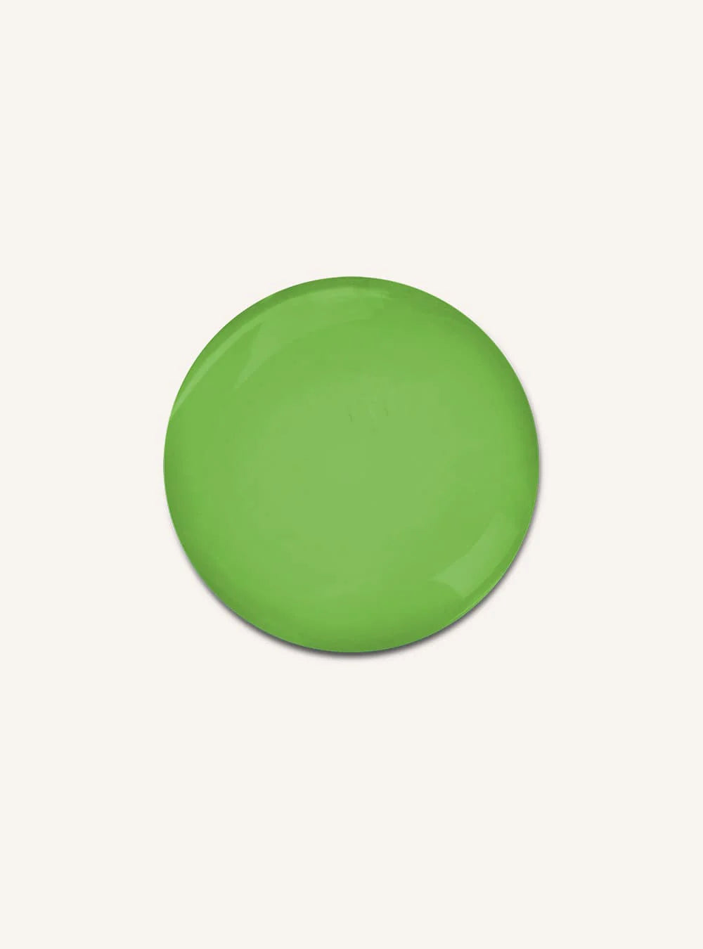 A single round green button badge or pin with a smooth glossy finish, centered on a plain off-white background.