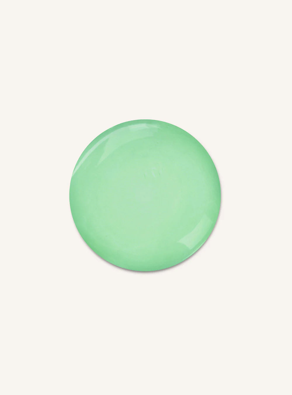 A smooth, glossy, circular mint green object, possibly a decorative stone, coaster, or tile, centered on a solid off-white background.