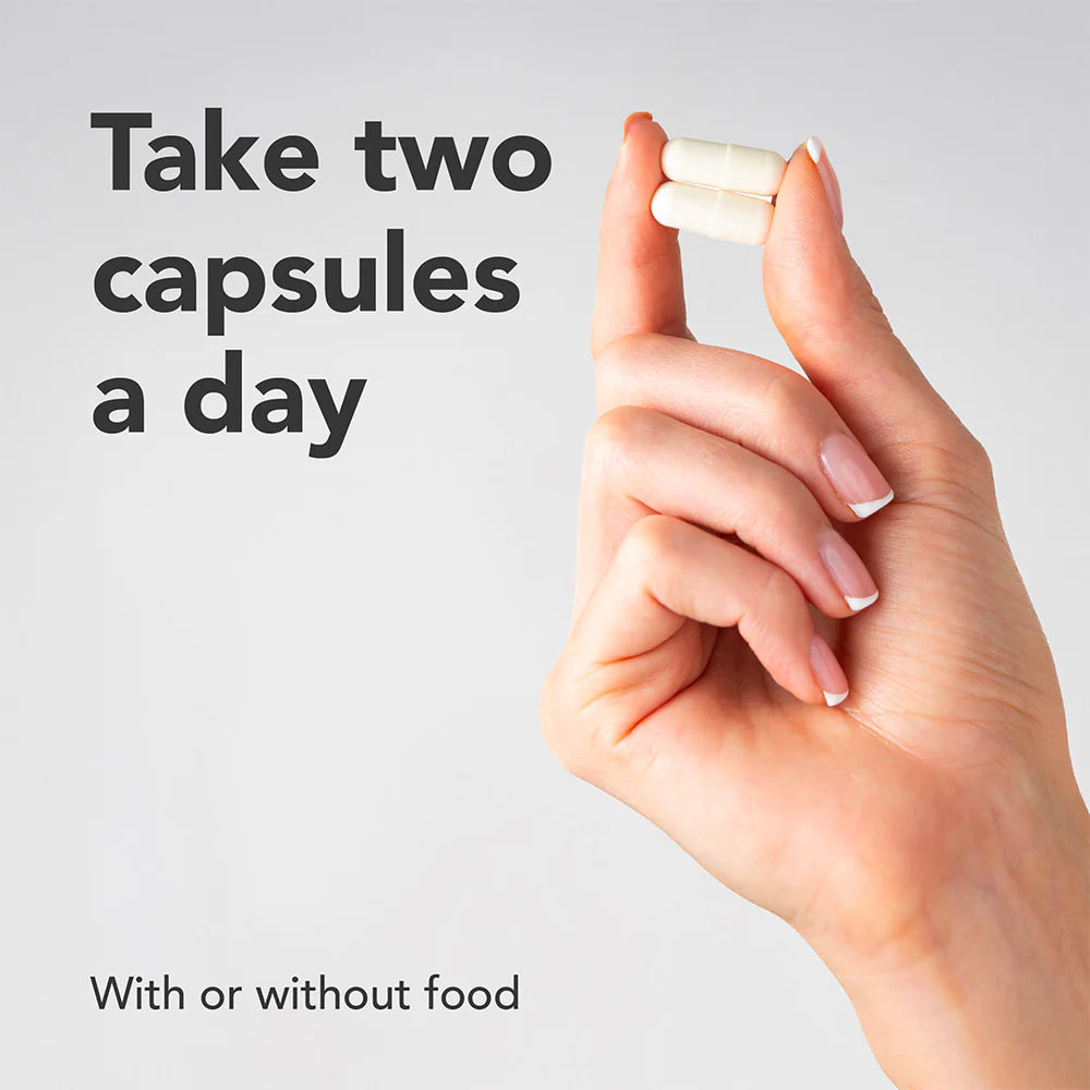 Hand holding two capsules with text on a light gray background