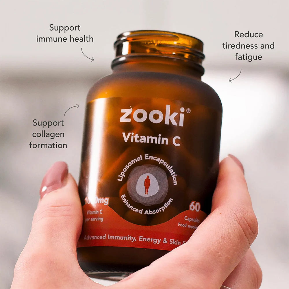 Hand holding a bottle of zooki Vitamin C with text highlighting benefits on a neutral background