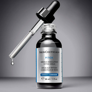 SkinCeuticals P-TIOX serum bottle with dropper on a gray background