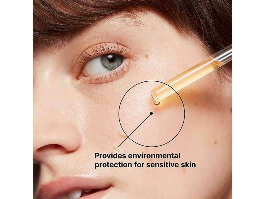 Close-up of a person's face with a dropper applying a product, labeled 'Provides environmental protection for sensitive skin'.