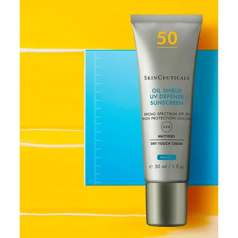 A 30 ml squeeze tube of SkinCeuticals Oil Shield UV Defense Sunscreen SPF 50, shown against a graphic background of yellow and blue.